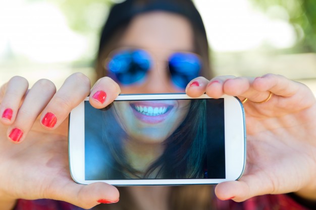 Mejora de la productividad incidiendo en una mayor felicidad de los trabajadores retrato de muchacha hermosa que toma un selfie con el telefono movil en 1301 3497